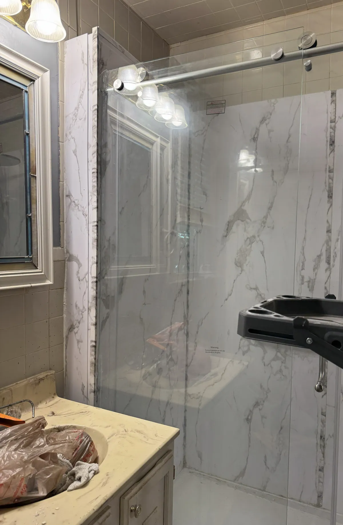 Bathroom remodel with a marble-look tiled glass shower